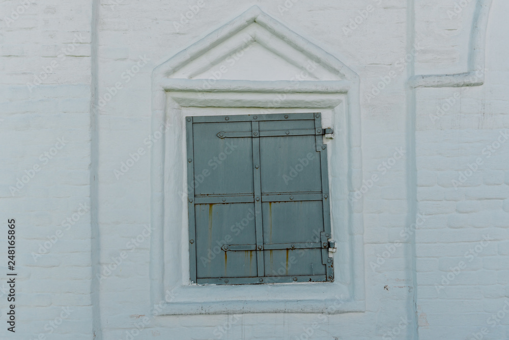 The White Brick Wall with the Closed Iron Window in Kolomenskoye, Moscow.