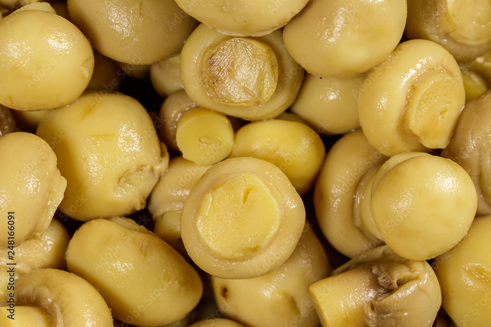 Food background of marinated mushrooms. Pickled champignons close-up