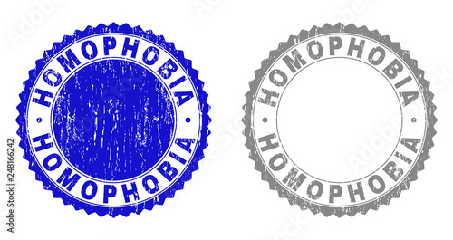 Grunge HOMOPHOBIA stamps isolated on a white background. Rosette seals with grunge texture in blue and grey colors. Vector rubber stamp imitation of HOMOPHOBIA title inside round rosette.