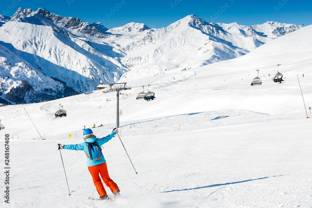 Back view of skier woman enjoys the winter ski resort.