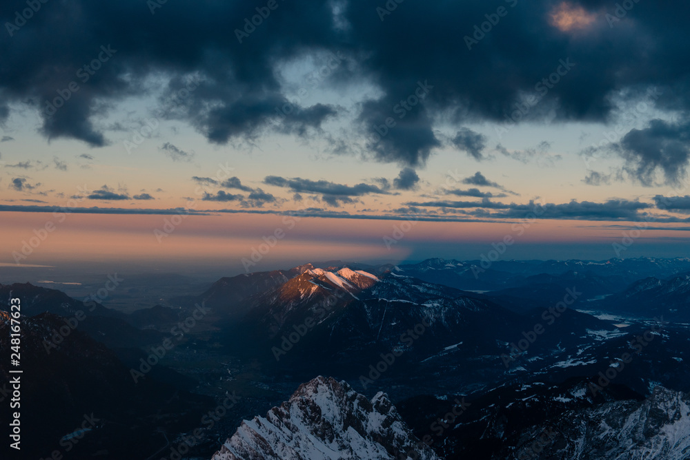 Purple sunset over the beautiful snowy Zugspitse mountains in German Alps