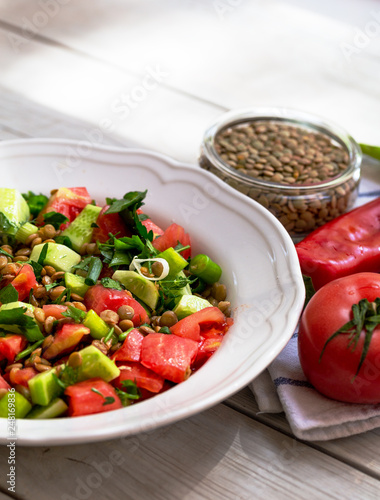 Plate with delicious lentils salad on wooden table