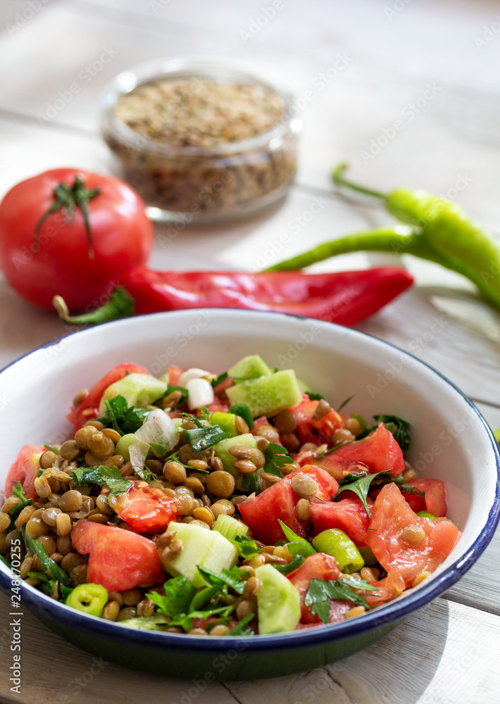 Plate with delicious lentils salad on wooden table