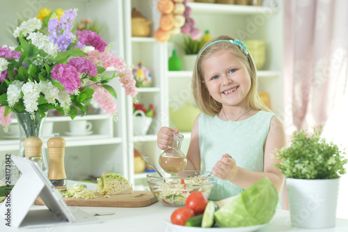 Portrait of cute little girl preparing salad