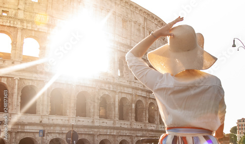 Photography Beautiful young woman in fashion dress alone in front of colosseum in Rome at sunset