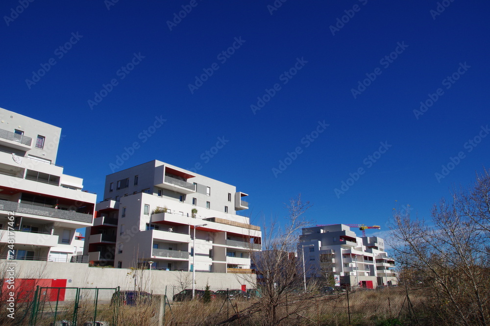 Ensemble d'immeuble moderne de logement blanc et rouge en construction avec ciel bleu Ensemble d'immeuble moderne de logement blanc et rouge en construction avec ciel bleu