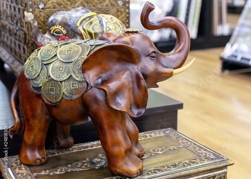 Wooden figurine of an elephant decorated with coins.