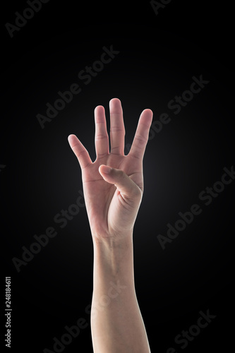 Hand up with four fingers of woman with rim light isolated on dark black background (clipping path) for number 4