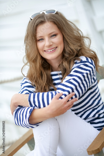 Cute woman sits on a Chair, in male clothes.