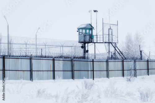 Prison guarding tower, fence with barbed wire