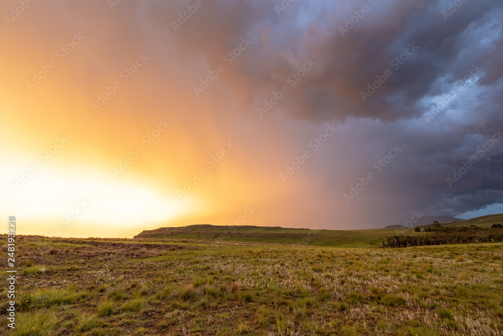 Nach dem Sturm kommt die Sonne! Wetterumschwung mit buntem Sonnenuntergang im Hochland Südafrikas