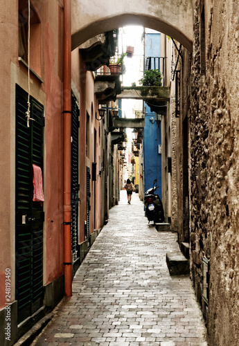 Single person in a long narrow inhabited lane of historic houses - Location  Lipari  Italy