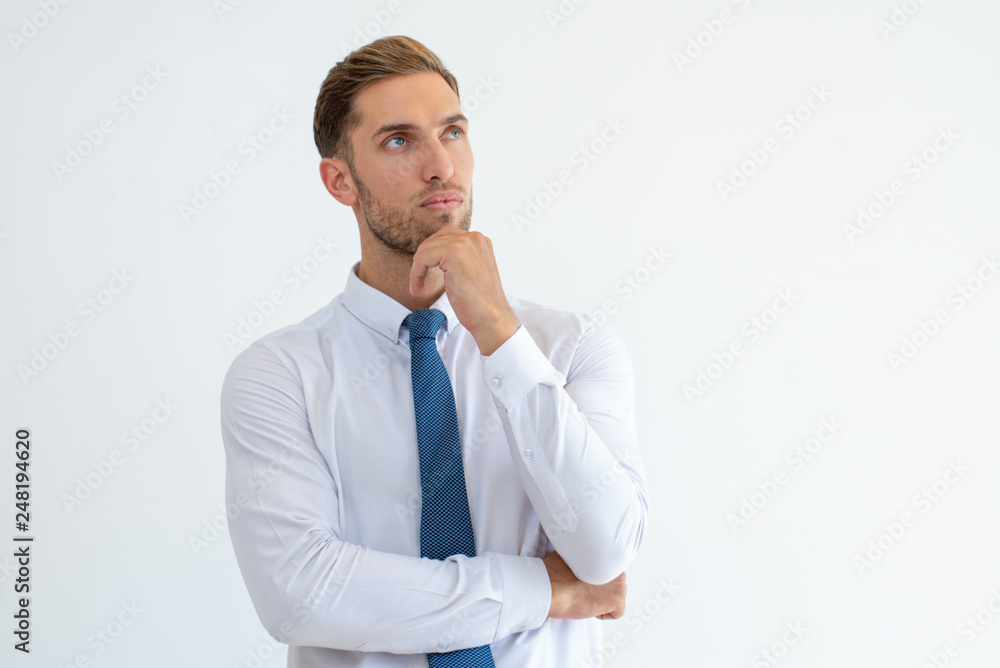 Pensive business man touching chin and looking away Pensive business man touching chin and looking away