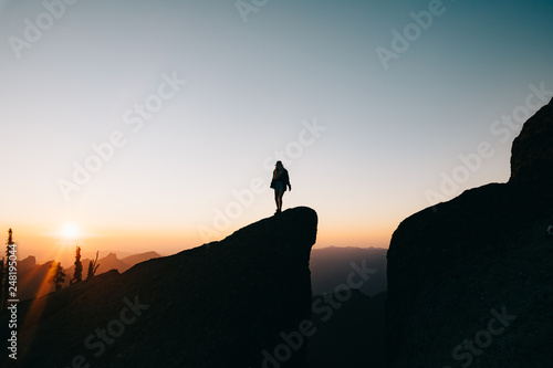 silhouette of woman on top of the mountain at sunset