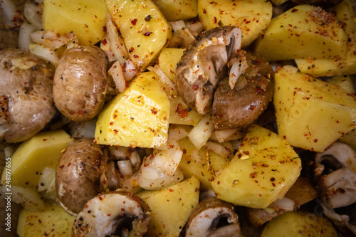 Simply, fast and tasty vegetarian dish from potato, brown champignon mushroom and onion with spices, ready for baking.