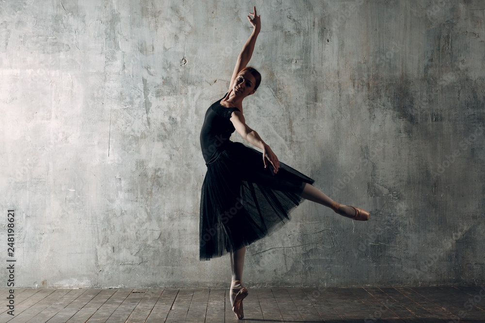Ballerina female. Young beautiful woman ballet dancer, dressed in  professional outfit, pointe shoes and black tutu. Photos | Adobe Stock