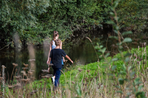 children walk in nature, along the pond