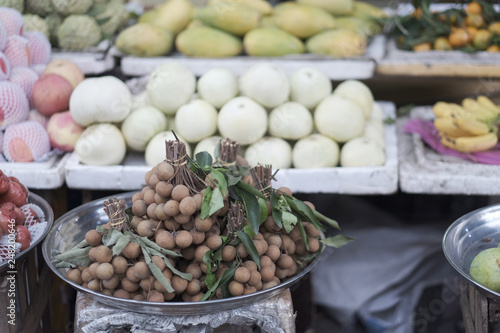 Dish with bunches of branches with longan fruits on the counter of the Asian market