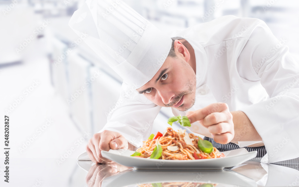 Chef in restaurant kitchen prepares and decorates meal with hands.Cook preparing spaghetti bolognese Chef in restaurant kitchen prepares and decorates meal with hands.Cook preparing spaghetti bolognese