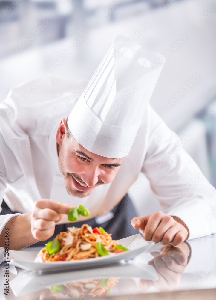 Chef in restaurant kitchen prepares and decorates meal with hands. Cook preparing spaghetti bolognese Chef in restaurant kitchen prepares and decorates meal with hands. Cook preparing spaghetti bolognese