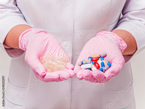 Placebo drugs concept. Doctor holds pills and placebo's. Hand in pink Gloves with Pills. Empty pills. Healthcare concept photo