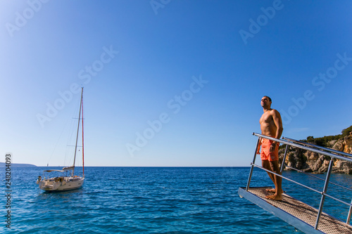 Athletic man on a yacht on a beach in Greece