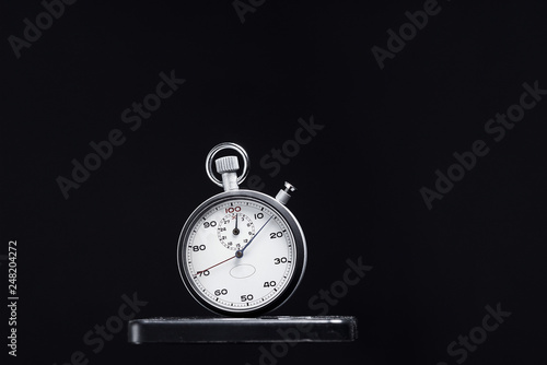 Close-up on black background, classic steel stopwatch.