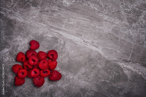 Fresh organic raspberries on a marble stone background with copy space photo