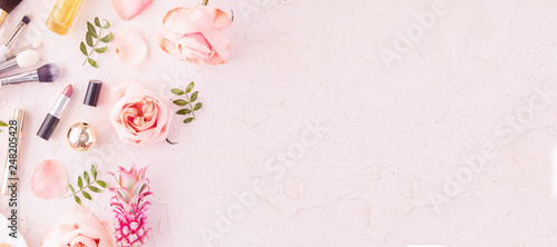 Fotografia Makeup products and make-up brush with pink flowers on pastel background