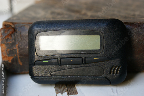 pagers, old vintage beeper. pager on the antique book photo