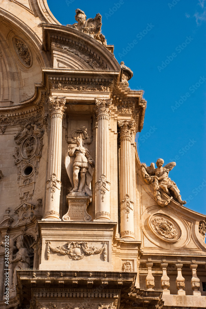 Part of facade of catholic cathedral  with statue in Murcia, Spain.Architecture of baroque and renaissance style.