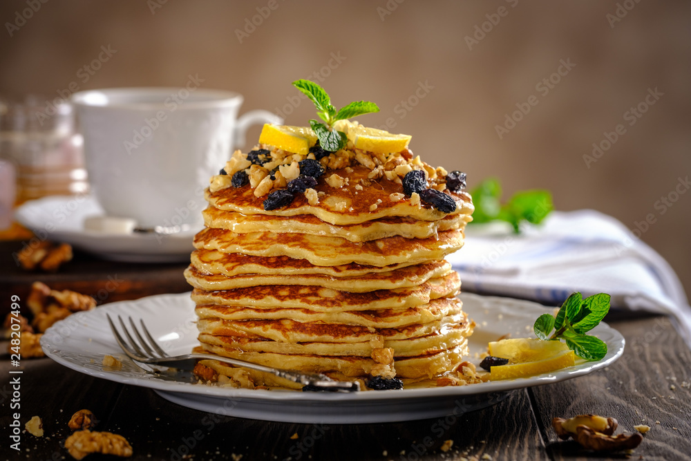 Pancakes with honey, nuts and raisins with a cup of coffee Pancakes with honey, nuts and raisins with a cup of coffee