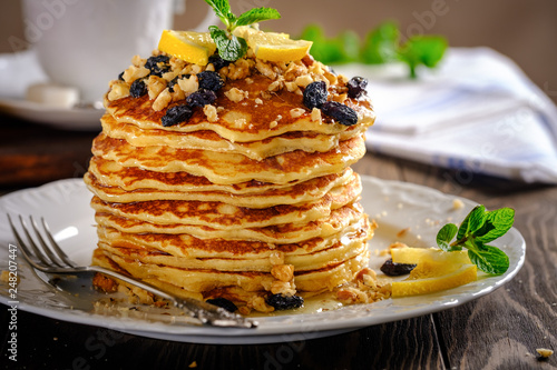 Pancakes with honey, nuts and raisins with a cup of coffee