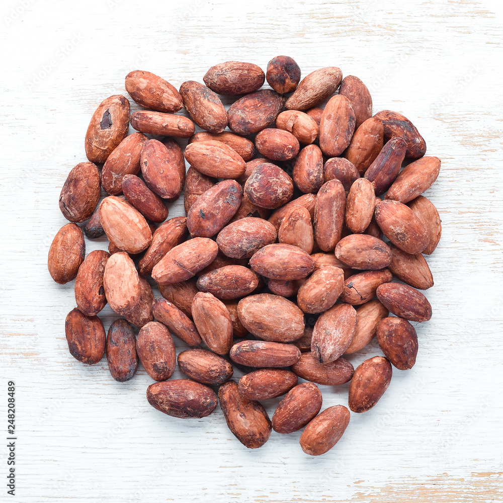 Obraz premium Cocoa beans on a white background. Top view. Free copy space.