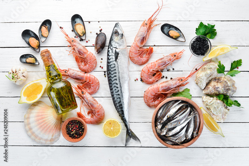 Seafood on a white wooden background. Fresh fish, shrimp, oysters and caviar. Top view. Free copy space.