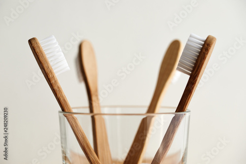 Close up of four bamboo toothbrushes in a glass
