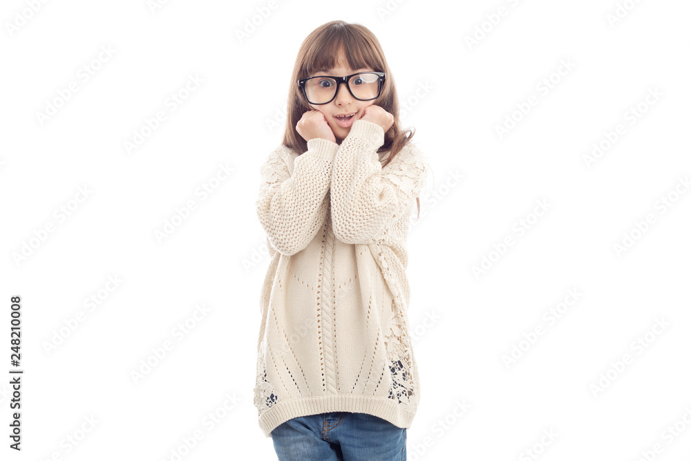 Surprised little girl in glasses pressed her hands to her face. Surprised little girl in glasses pressed her hands to her face.