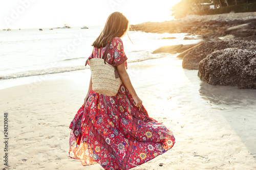 Beautiful girl in boho maxi dress on the beach
