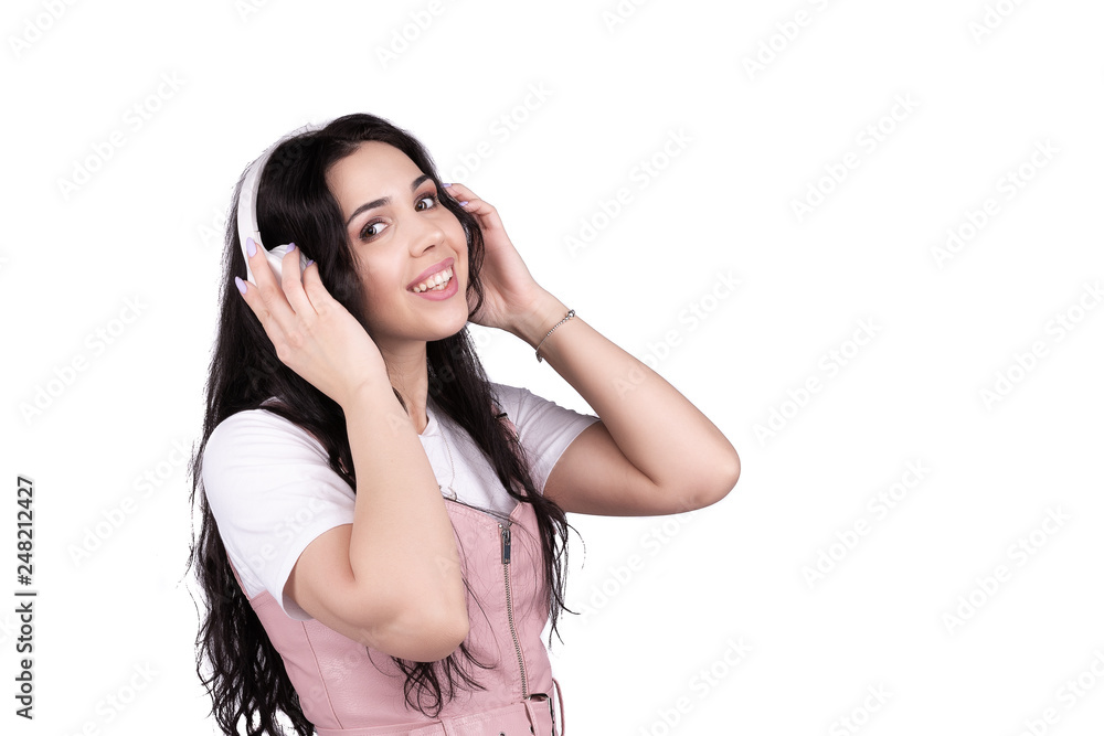 Attractive smiling brunette holding white headphones and wearing them to her head, happy woman listen her favourie music Attractive smiling brunette holding white headphones and wearing them to her head, happy woman listen her favourie music