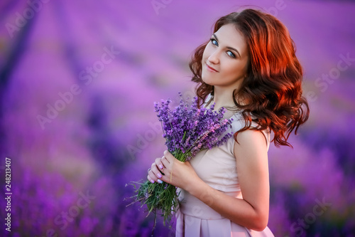 beautiful bride in luxurious wedding dress in purple lavender flowers. Fashion romantic stylish woman with violet bouquet. Alluring slim girl in sunset over lavenda waiting for groom - Provence France