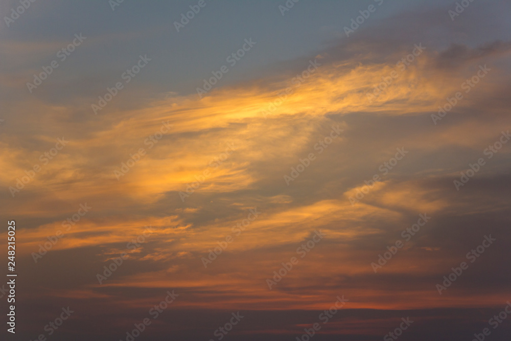 bright yellow and pink clouds in a dark blue sunset sky