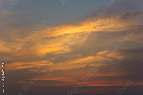 bright yellow and pink clouds in a dark blue sunset sky