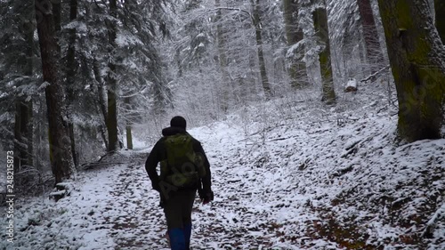young man with backpack doing hiking in snowy and foggy forest / yenice forest karabuk in turkey