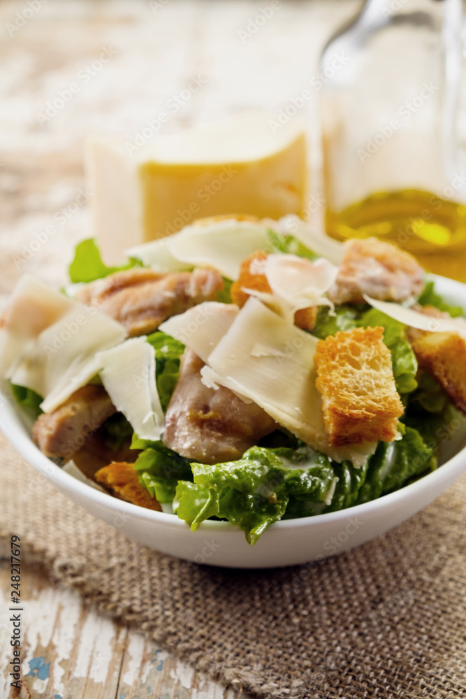Caesar salad with chicken and herbs on the table, Caesar sauce, Parmesan cheese Caesar salad with chicken and herbs on the table, Caesar sauce, Parmesan cheese