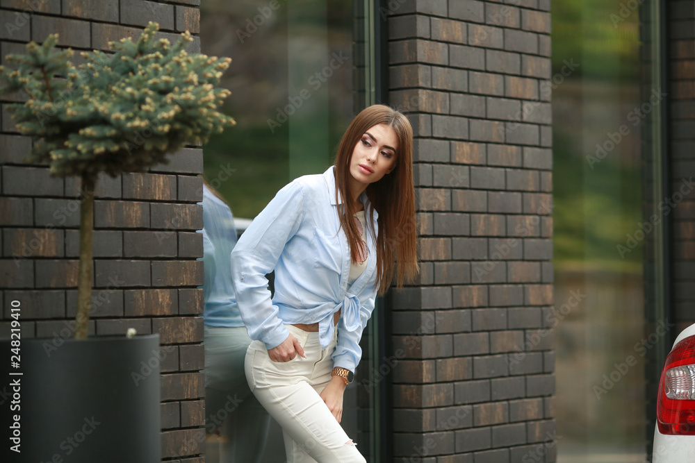 Full Length Portrait of Trendy Hipster Girl Standing at the dark Brick Wall Background. Urban Fashion Concept. Copy Space. Full Length Portrait of Trendy Hipster Girl Standing at the dark Brick Wall Background. Urban Fashion Concept. Copy Space.