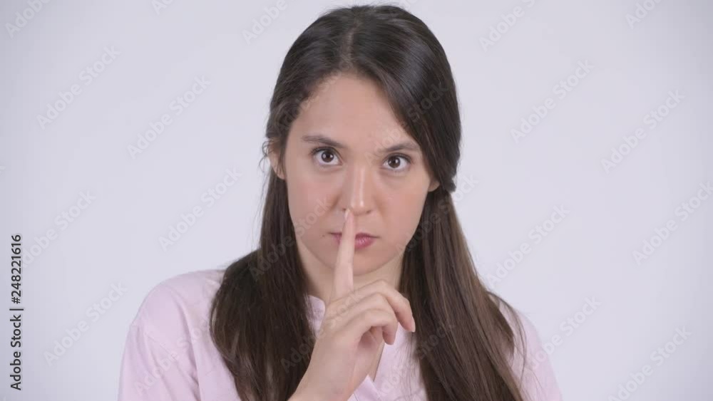 Face of young multi-ethnic businesswoman with finger on lips Face of young multi-ethnic businesswoman with finger on lips