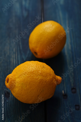Two whole lemons lying on a wooden background