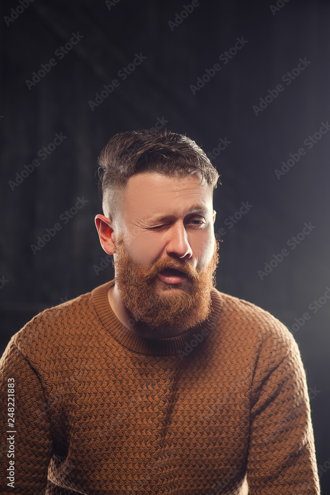 Fototapeta premium Cheerful bearded man greets by taking off a hat - studio shots
