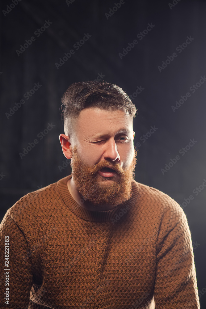 Cheerful bearded man greets by taking off a hat - studio shots