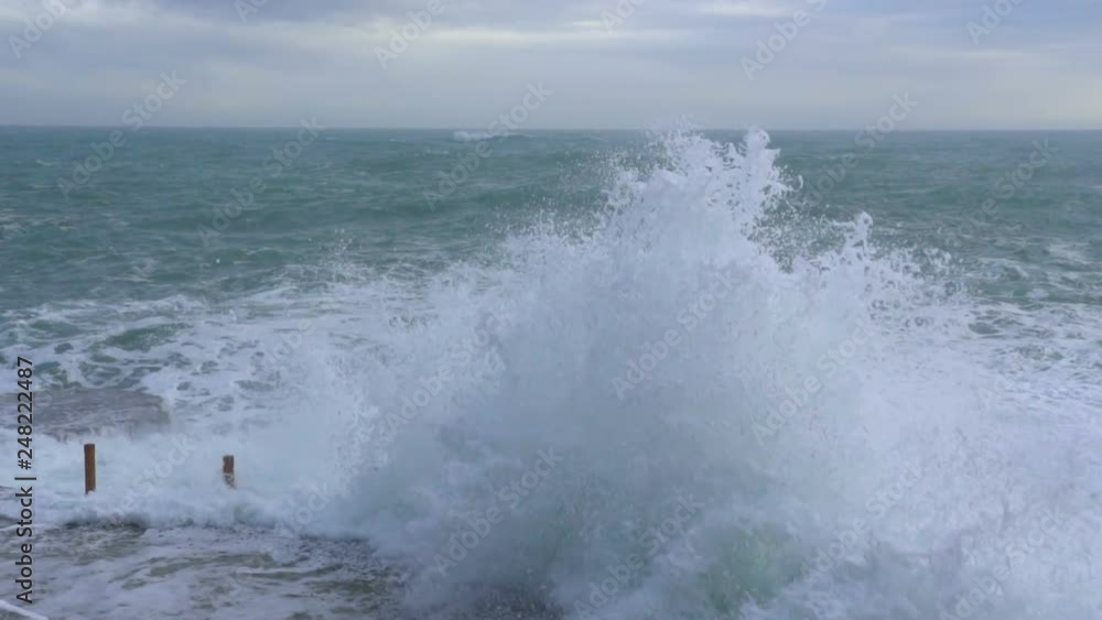 Huge waves break on the stone coast, slow motion Huge waves break on the stone coast, slow motion